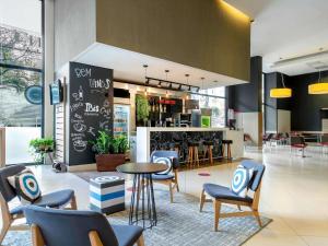 a lobby with chairs and a table and a bar at ibis Belo Horizonte Afonso Pena in Belo Horizonte