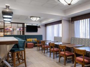 a dining room with tables and chairs and a couch at Hampton Inn Atlanta-Peachtree Corners/Norcross in Norcross