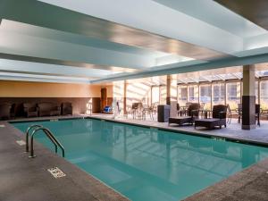 a pool in a hotel with chairs and tables at Hampton Inn Atlanta-Peachtree Corners/Norcross in Norcross
