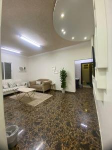 uma sala de estar com um sofá e uma mesa em شقة غرفتين نوم و دورة مياه و صاله كبيره ومطبخ حي الرمال بالرياض em Riyadh