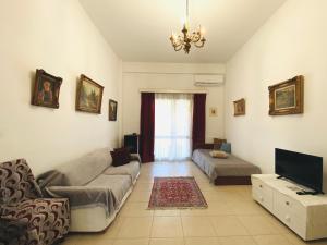 a living room with a couch and a tv at THE MANSION OF DIONISOS AND DIMITRAS in Linariá