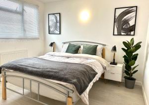 - une chambre avec un lit et une plante dans l'établissement Entire 5 bedroom detached house free Parking 5 mins driving to Bicester Village, à Bicester