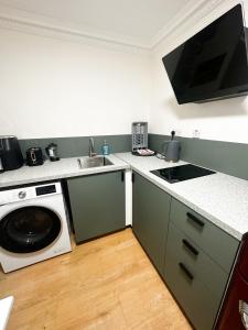 a kitchen with a sink and a washing machine at Flat 3 Stay In Aldgate Apartments in London