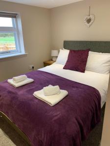 a bedroom with a bed with two towels on it at The Granary, quiet countryside location near York in Wilberfoss