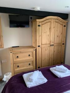a bedroom with a bed and a dresser with two towels at The Granary, quiet countryside location near York in Wilberfoss