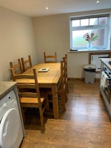 a kitchen with a wooden table with chairs and a window at The Granary, quiet countryside location near York in Wilberfoss