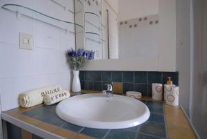 a bathroom with a white sink and a mirror at Nughe 'e' Oro Guesthouse in Nuoro