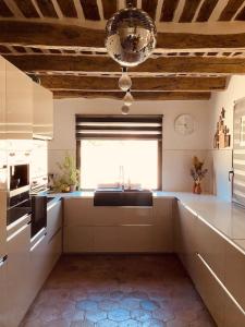 cocina grande con fregadero y ventana en Villa au sommet des collines en toute intimité, en Vidauban