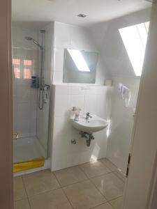 a white bathroom with a sink and a shower at Gästehaus Niki in Tauberbischofsheim