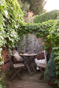 un tavolo e due sedie seduti su una terrazza di legno di Badger Cottage at Alde Garden a Saxmundham