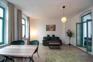 a living room with a couch and a table and chairs at Room&Go: Zentral - Balkon - Arbeitsplatz in Halle an der Saale