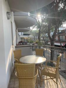 a patio with a table and chairs on a balcony at San Martino-Flexrent Immobiliare Abissinia in Riccione