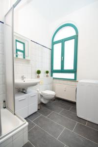 a bathroom with a sink toilet and a window at Room&Go: Zentral - Balkon - Arbeitsplatz in Halle an der Saale