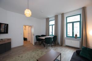 a living room with a table and chairs and a couch at Room&Go: Zentral - Balkon - Arbeitsplatz in Halle an der Saale
