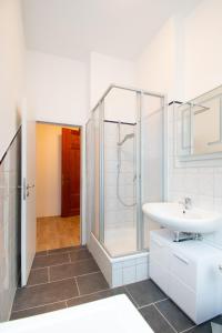 a bathroom with a sink and a shower at Room&Go: Zentral - Balkon - Arbeitsplatz in Halle an der Saale