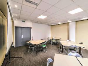 une salle de classe avec des tables et des chaises dans une salle dans l'établissement Ibis Budget Toulon Centre, à Toulon