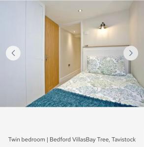 een slaapkamer met een bed en een houten deur bij Bay Tree in Tavistock