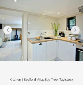 een keuken met witte kasten en een keuken iberostar villasy boom bij Bay Tree in Tavistock