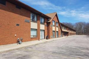 an empty parking lot next to a brick building at Travelodge by Wyndham Welland in Welland