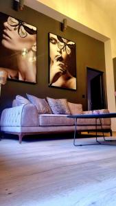 a living room with a couch and pictures on the wall at TRESOR Delux Apartment in Osijek