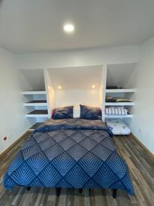 1 dormitorio con 1 cama con edredón azul y blanco en La Maison de Jars, en Jars