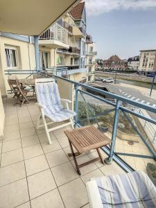 un balcone con 2 sedie e un tavolo su un edificio di fleur de sel appartement face à la mer a Wimereux