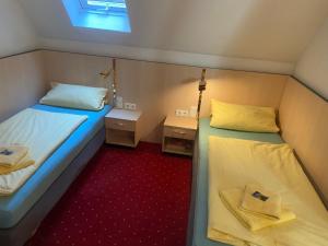 タウバービショフスハイムにあるGästehaus Nikiのベッド2台と窓が備わる小さな客室です。