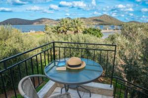 a hat on a table on a balcony with a view of the ocean at Elounda Windmills Apartment in Elounda