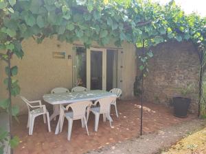 a patio with a table and chairs under an arch at La Cour des Miracles in Vallon-Pont-dʼArc