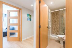 a bathroom with a toilet and a glass door at Top family apartment by Lofties in Terrassa