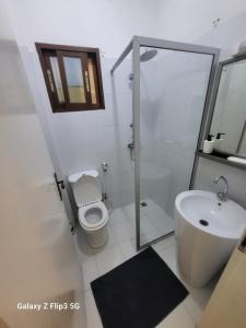 a white bathroom with a toilet and a sink at Paradis Appartement in Ngor