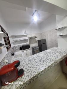 a kitchen with a counter with a red appliance on it at Paradis Appartement in Ngor