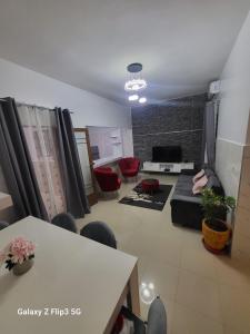 a living room with a couch and a table and chairs at Paradis Appartement in Ngor
