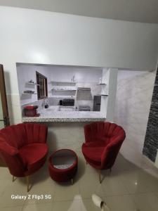 Ngor的住宿－Paradis Appartement，两个红色的椅子和一个凳子在房间里