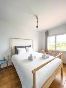 a bedroom with a large white bed with a window at Majordoms - Apartment Cau del Llop, Llança in Llança