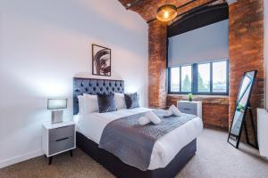 Un dormitorio con una cama y una ventana grande. en Meadow Mill by Staycay, en Stockport