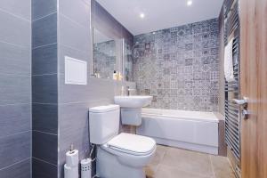 a bathroom with a toilet and a sink and a tub at Meadow Mill by Staycay in Stockport