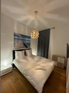 a bedroom with a large white bed and a chandelier at Nice Port, French Riviera in Nice
