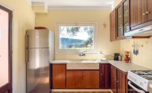 Una cocina con refrigerador de acero inoxidable y ventana. en Majordoms - Can Vedruna, Girona, en Riudellots de la Creu