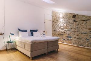 1 dormitorio con cama y pared de piedra en Can Blanc de Montagut, en Montagut