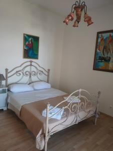 a bedroom with a bed and a painting on the wall at Batsi Bay View Maisonette in Andros