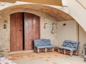 dos sillas sentadas frente a una puerta de madera en Private country house with pool and barbecue, en Girona