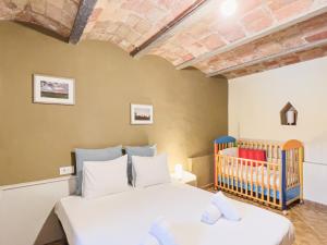 een slaapkamer met 2 bedden en een wieg bij Private country house with pool and barbecue in Girona