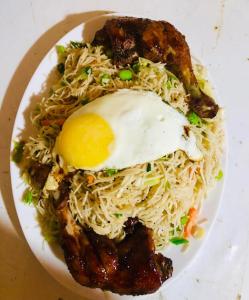 a plate of noodles with an egg on top at Lotus cool hotel and restaurant in Ibbagomuwa