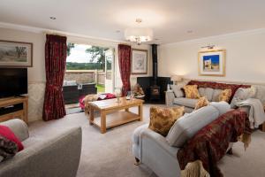a living room with two couches and a television at Dryburgh Steading Three in Saint Boswells