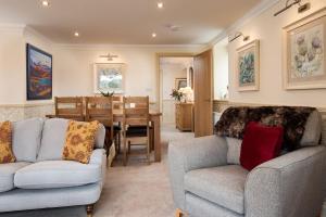a living room with two couches and a dining room at Dryburgh Steading Three in Saint Boswells