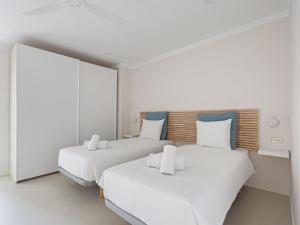 2 camas en una habitación blanca con paredes blancas en Majordoms - Ca les Cosines 47, en Banyoles