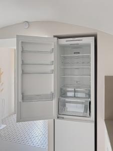 un réfrigérateur vide avec une porte ouverte dans une pièce dans l'établissement Majordoms - Ca les Cosines 47, à Banyoles
