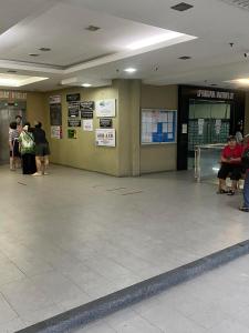 un vestíbulo con gente esperando su equipaje en un aeropuerto en Ain Studio Apartment, en Kota Bharu