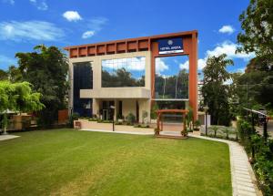 a building with a lawn in front of it at Hotel Aketa Rajpur Road Dehradun, Dehradun in Dehradun